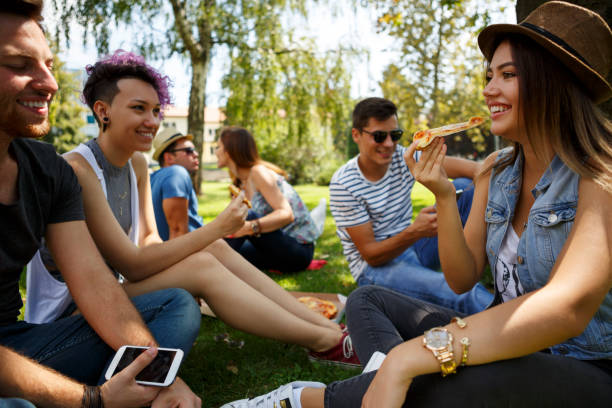 Friends eating pizza outside