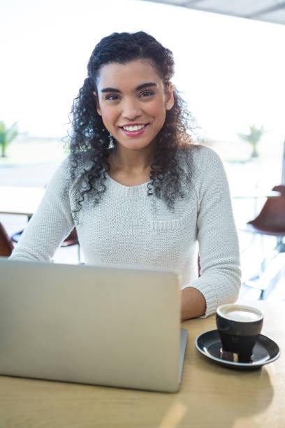 istock Woman using laptop and a coffee cup on the table in the coffee shop 652203388