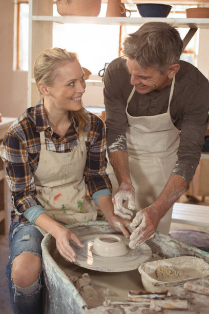 istock Male potter assisting female potter 652210846