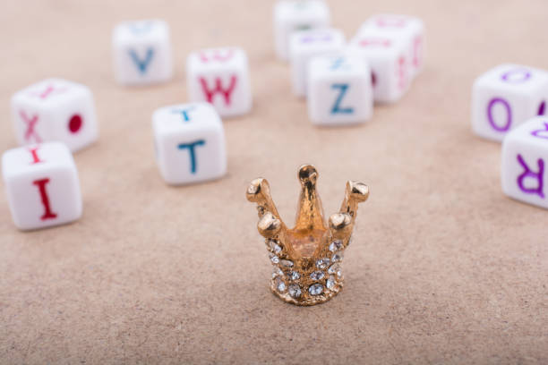 istock Golden color crown model in front of letter cubes 652225096