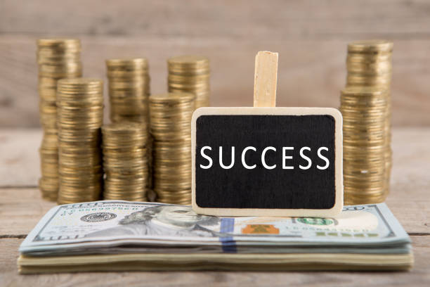 istock Stacks of coins and dollar bills, blackboard with text 
