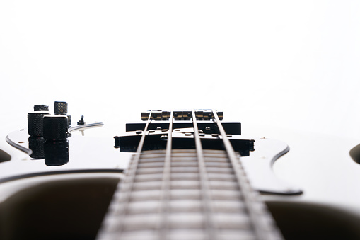 Extreme close up view of steel strings and bridge of an acoustic guitar.