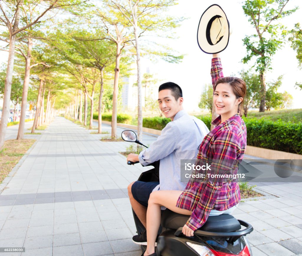 happy young couple riding  scooter in town Motorcycle Stock Photo