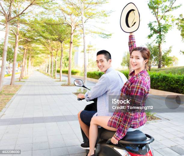 Happy Young Couple Riding Scooter In Town Stock Photo - Download Image Now - Motorcycle, Couple - Relationship, Riding