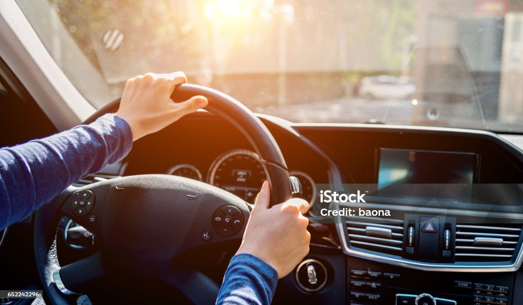 driving A woman in a luxury car, with her hand on the wheel. Steering Wheel Stock Photo