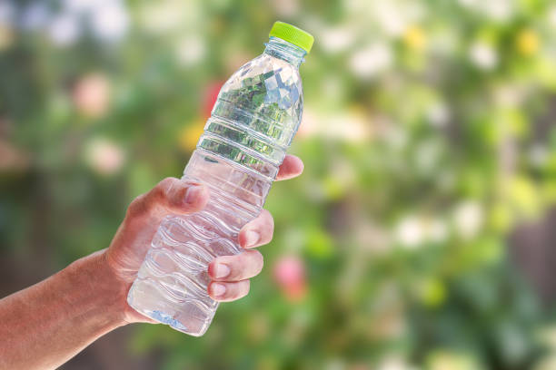 istock Man's hand holding water bottle on blurred green bokeh background 652251882