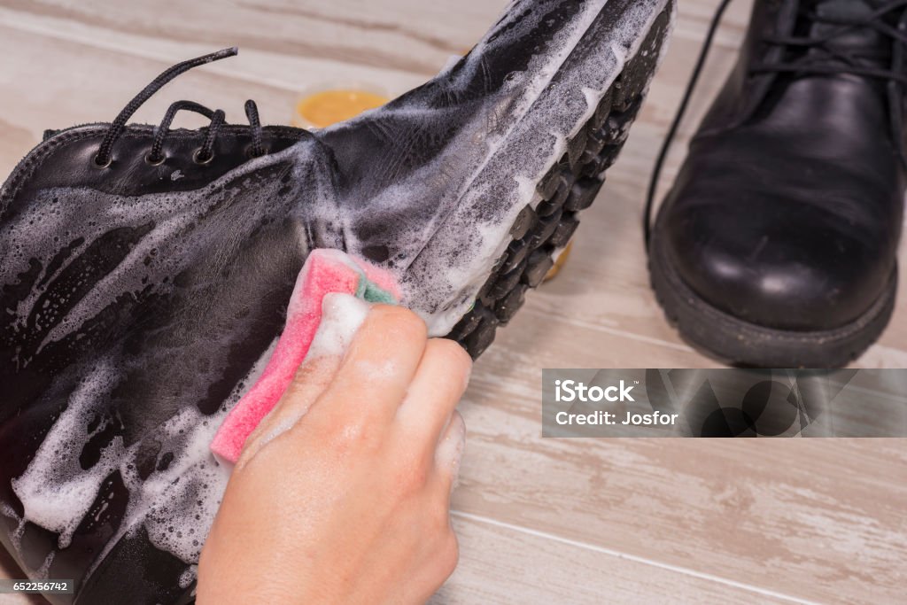 Footwear cleaning. Cleaning leather boots. Leather Stock Photo