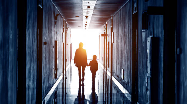 walking together Profile of mother and son walking into the light. light at the end of the tunnel photos stock pictures, royalty-free photos & images