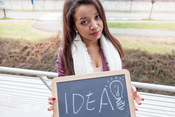 young attractive businesswoman shows a blackboard marked with business concepts