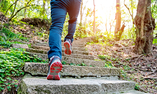 Low section of man running on forest stairs in China.