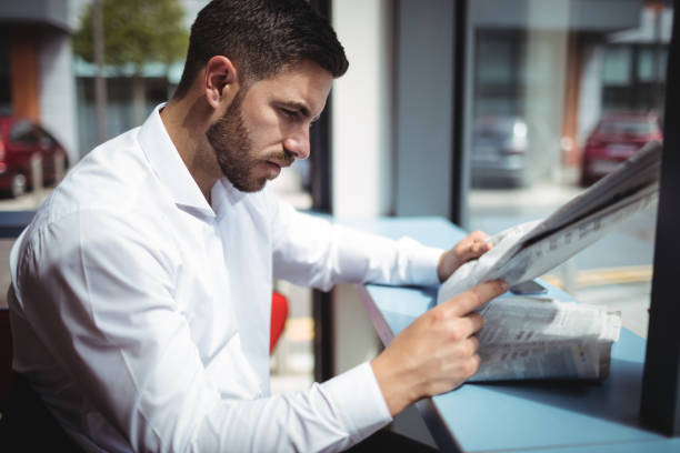 istock Businessman reading newspaper in office 652309448