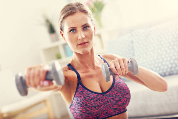 istock Woman exercising with dumbbells at home 652317614