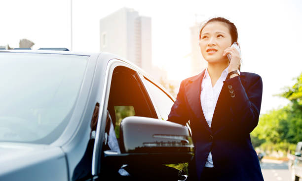 istock businesswoman talking on mobile phone by her car 652317738