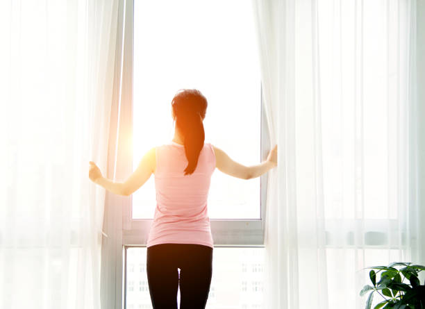 istock Asian woman open curtains 652320948