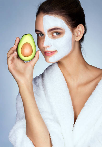 istock Pretty young woman holding half an avocado in hand. 652324934