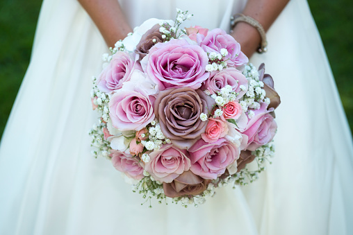Close-up photo from a bride holding her pink wedding bouquet
