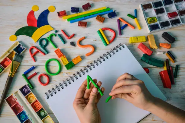 Photo of hands make April Fools' Day text made with plasticine