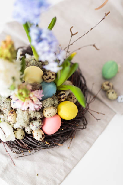 istock Flower arrangement in a nest with easter eggs on a white table 652363074