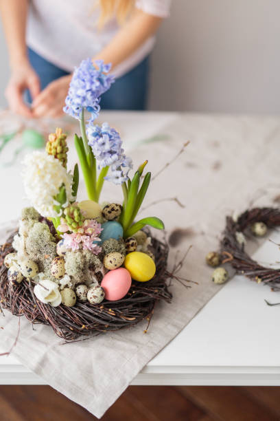 istock Flower arrangement in a nest with easter eggs on a white table 652363114
