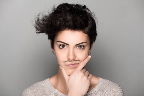 Woman with Mustaches Confident Woman with Drawn Mustaches on Gray Background women movember mustache facial hair stock pictures, royalty-free photos & images