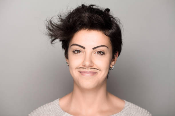 Woman with Mustaches Smiling Woman with Drawn Mustaches on Gray Background women movember mustache facial hair stock pictures, royalty-free photos & images