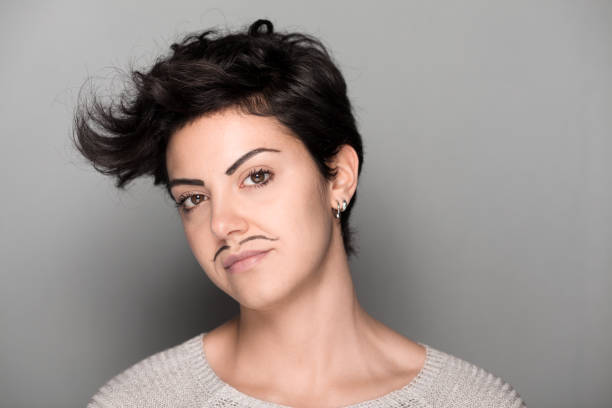 Woman with Mustaches Serious Woman with Drawn Mustaches on Gray Background women movember mustache facial hair stock pictures, royalty-free photos & images