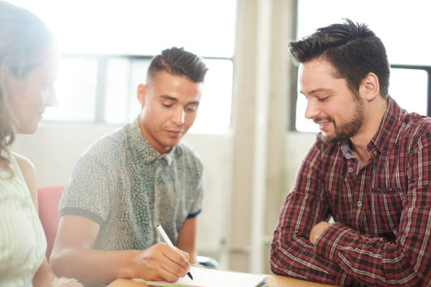 istock Unposed group of creative business entrepreneurs in an open concept office brainstorming together on a digital tablet 652370154