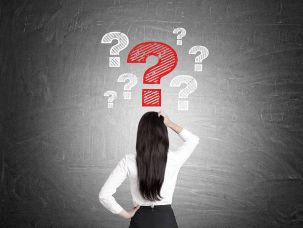 istock Woman looks at question marks on blackboard 652377550