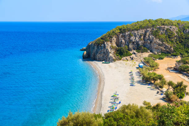 una vista de playa de tsambou con agua de mar azul, isla de samos, grecia - parasol pine fotografías e imágenes de stock