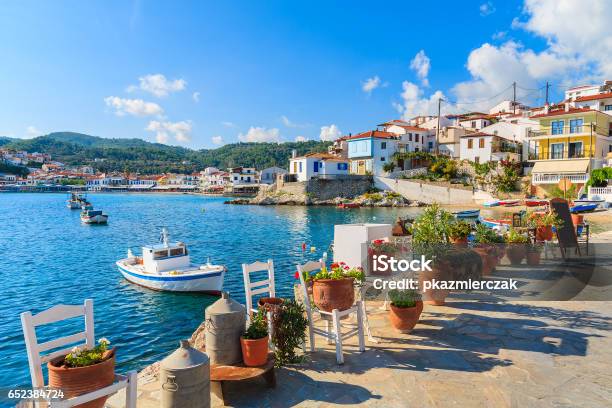 Flower Pots On And View Of Fishing Boats Anchoring In Kokkari Bay Samos Island Greece Stock Photo - Download Image Now