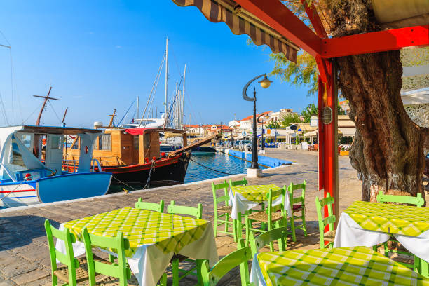 tables in greek tavern in pythagorion port on samos island, greece - dining nautical vessel recreational boat europe imagens e fotografias de stock