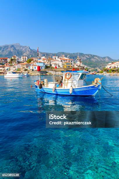 Typical Blue And White Colour Fishing Boat On Azure Crystal Clear Sea Water In Kokkari Port Samos Island Greece Stock Photo - Download Image Now