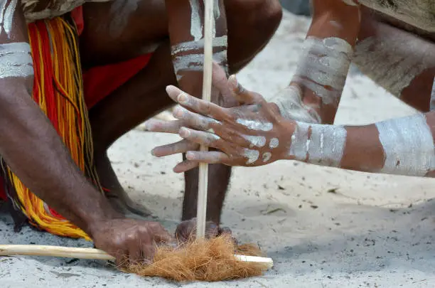 Hands of Yugambeh Aboriginal warriors men demonstrate  fire making craft during Aboriginal culture show in Queensland, Australia.