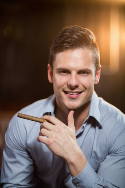 istock Smiling man holding a cigar in bar 652391742