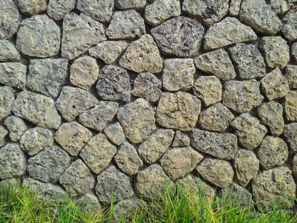 istock Rock wall and fresh green grass background 652392038