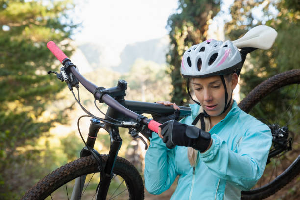 istock Female mountain biker carrying her bicycle in the forest 652417744