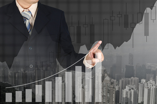 Double exposure businessman hand touching virtual panel of growth bar chart on financial graph chart and city background, business success concept.