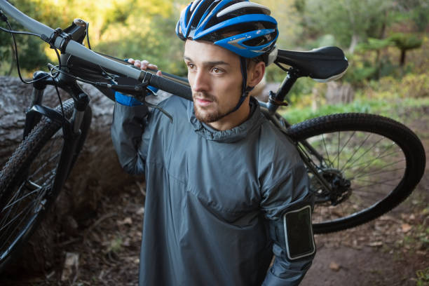 istock Male mountain biker carrying bicycle in the forest 652423704