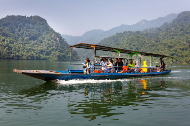 turistas en el barco van a disfrutar y explorar lago ba ser. sorprendentes paisajes del ba ser el lago en la provincia de bac kan, vietnam - ba kan fotografías e imágenes de stock