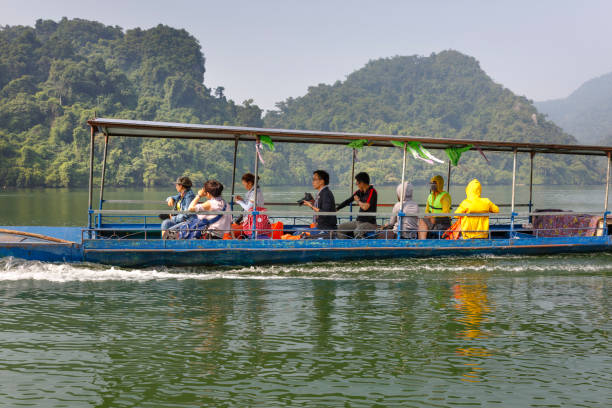 turyści na łodzi będą cieszyć się i odkrywać jezioro ba be. oszałamiająca sceneria jeziora ba be w prowincji bac kan, wietnam - ba kan zdjęcia i obrazy z banku zdjęć