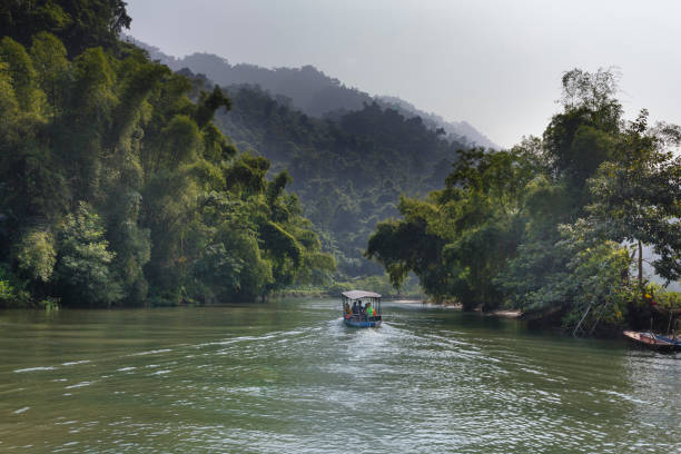 turistas en el barco van a disfrutar y explorar lago ba ser. sorprendentes paisajes del ba ser el lago en la provincia de bac kan, vietnam - ba kan fotografías e imágenes de stock