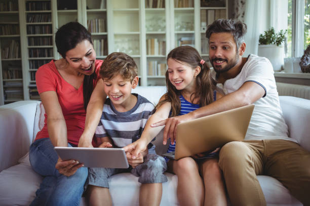 istock Smiling family sitting on sofa and pointing at digital tablet 652482018