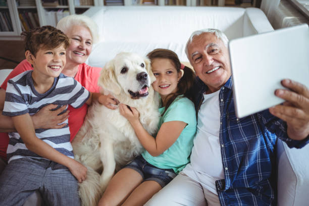 grands-parents et petits-enfants prenant un selfie avec tablette numérique - wireless technology cheerful granddaughter grandmother photos et images de collection