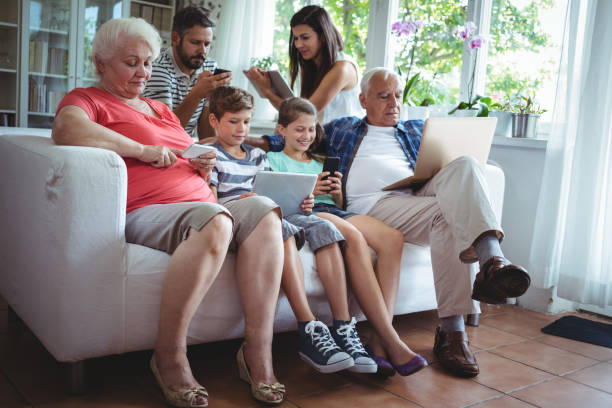 mehr-generationen-familie mit laptop, handy und digital-tablette - grandmother senior adult child multi generation family stock-fotos und bilder