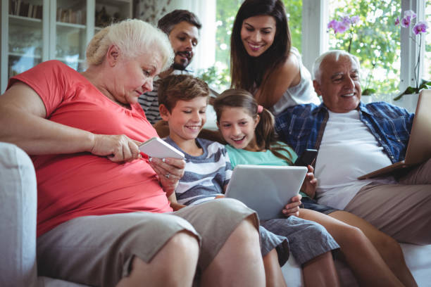 glückliche mehr-generationen-familie mit laptop, handy und digital-tablette - grandmother senior adult child multi generation family stock-fotos und bilder