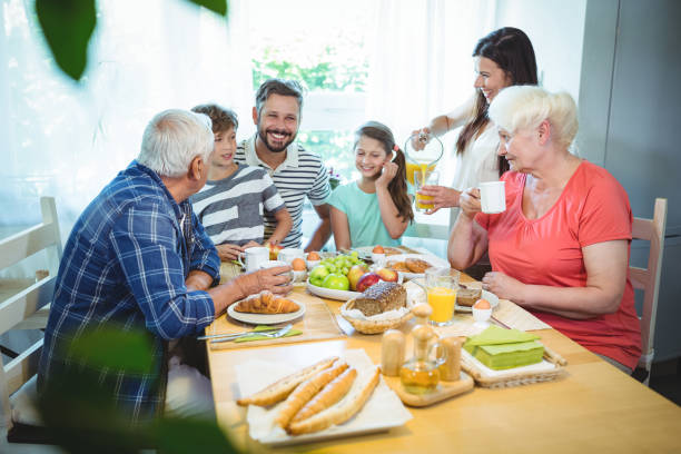 famiglia multi-generazione seduta a tavola - 60s senior adult breakfast cheerful foto e immagini stock