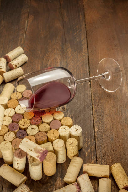 istock Glass of red wine and corks on dark background 652513036