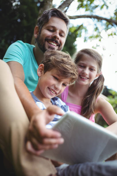 istock Father and kids using digital tablet in garden 652513880