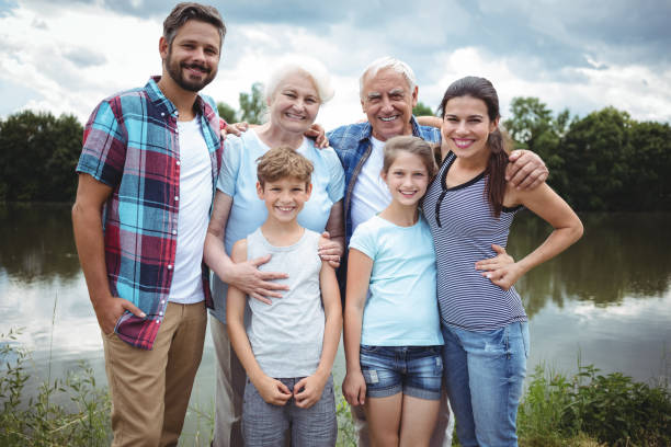 glücklich generationsübergreifende familie stand in der nähe eines flusses - grandmother senior adult child multi generation family stock-fotos und bilder