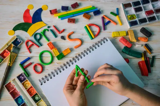 Photo of hands make April Fools' Day text made with plasticine